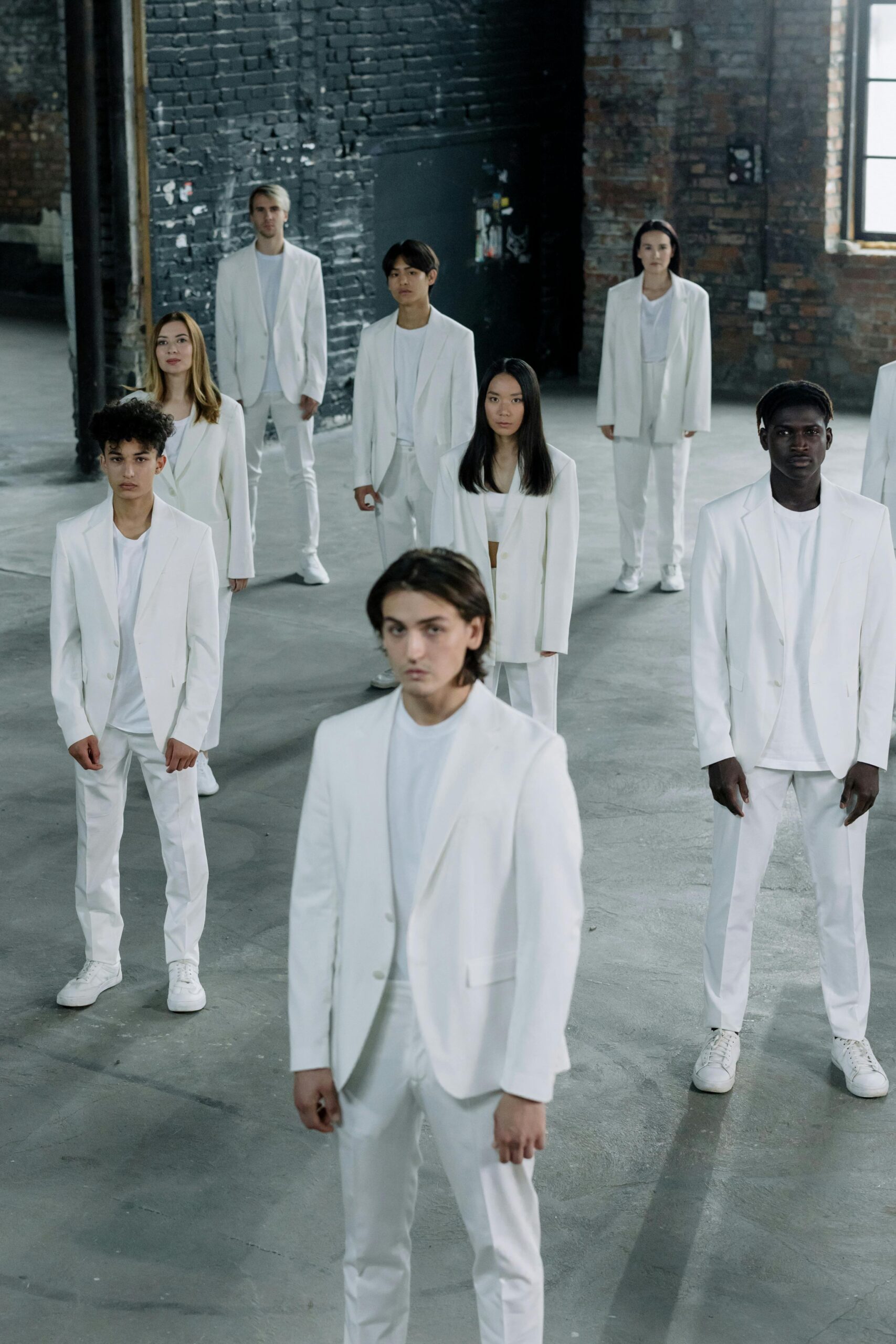 The #1 Mistake Companies Make When Hiring (And How to Fix It) 5 A diverse group of professionals dressed in white standing in an industrial-style room, symbolizing a modern, structured approach to hiring and team-building.