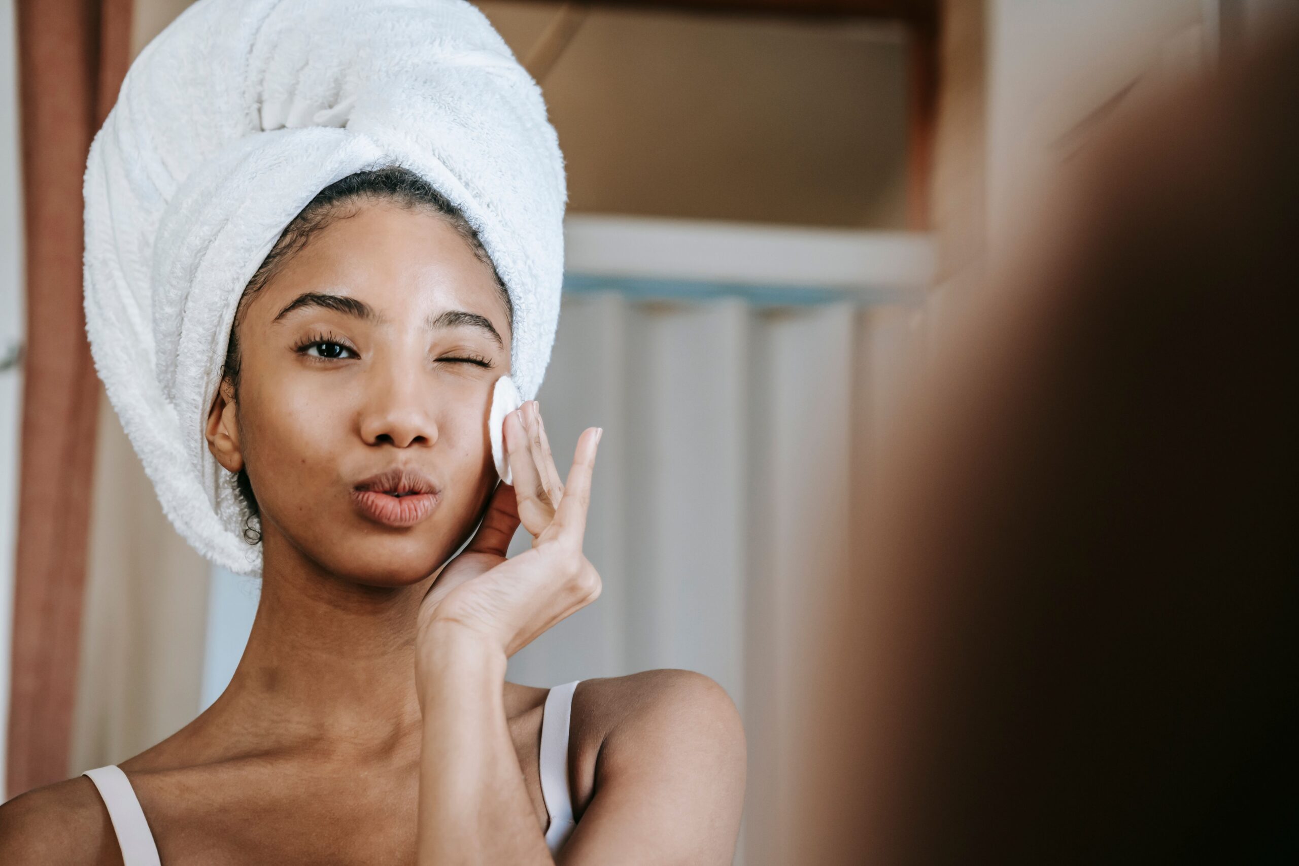 Woman applying skincare and smiling