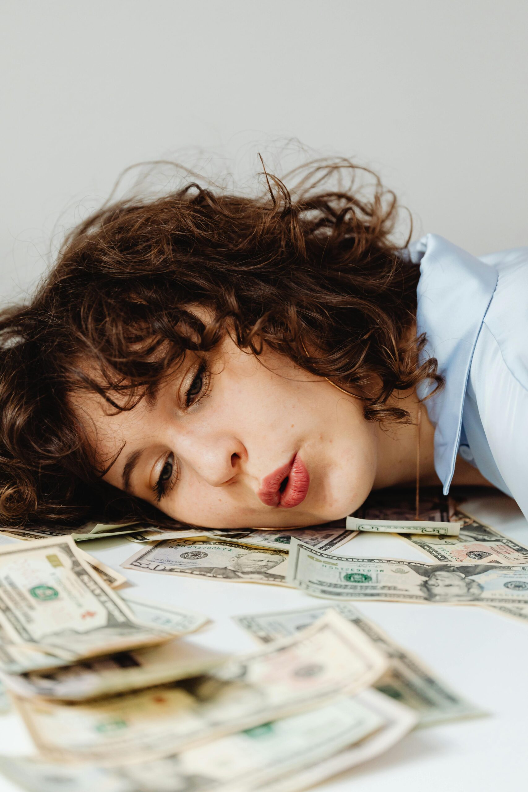 woman blowing money on a table